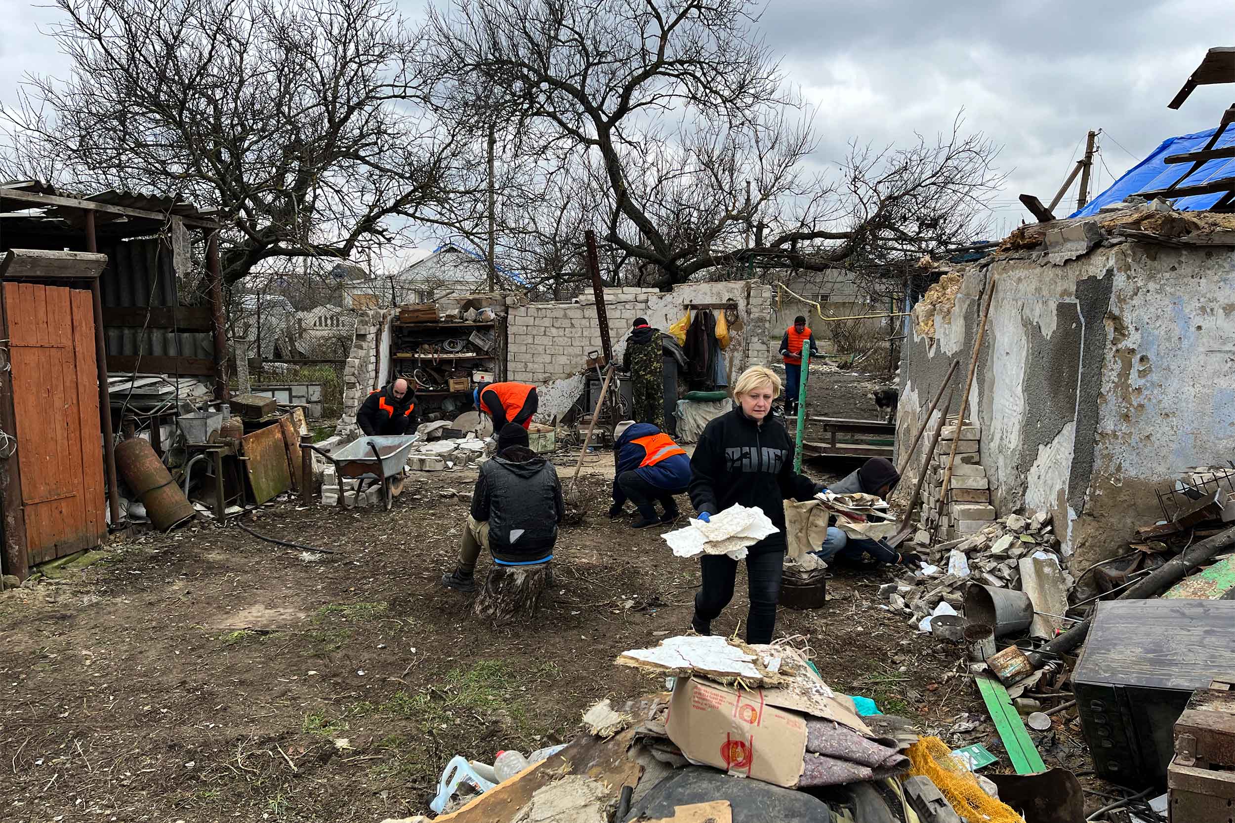Tatyana Chygryn, Posad-Pokrovs’ke resident with volunteers of the Ukrainian charity Dobrobat starting the cleanup of her parents’ home. © IWPR