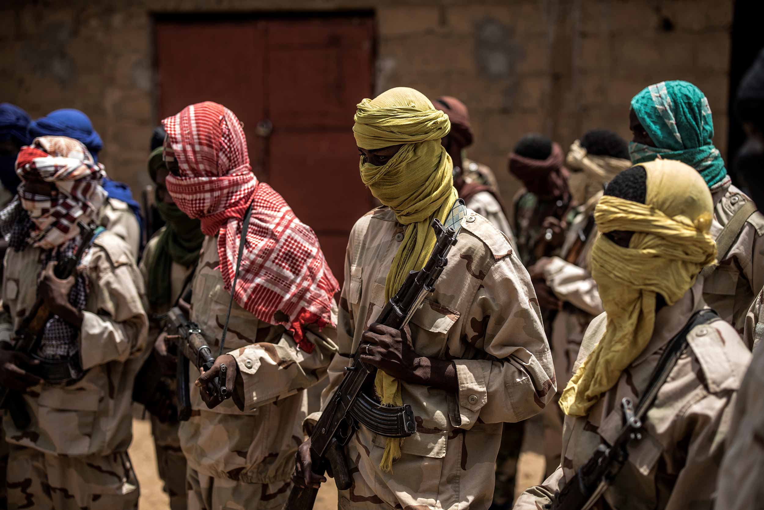 A group of Fulani militiamen stand ready with their weapons on July 6, 2019, at an informal demobilisation camp in Sevare run by Sekou Bolly, a local Fulani businessman whose goal is to take away young Fulani from the morse of jihadism. © Marco Longari/AFP via Getty Images