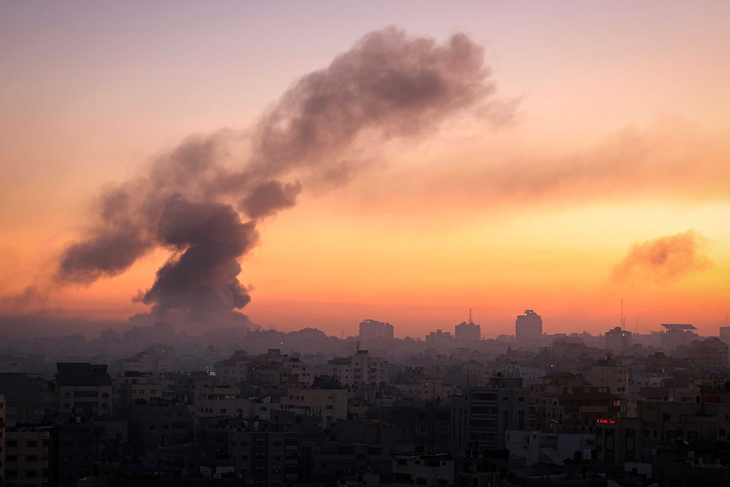 Fire and smoke rise above buildings in Gaza City during an Israeli air strike, on October 13, 2023, as raging battles between Israel and the Hamas movement continue for the sixth consecutive day. © Mahmud Hams/AFP via Getty Images
