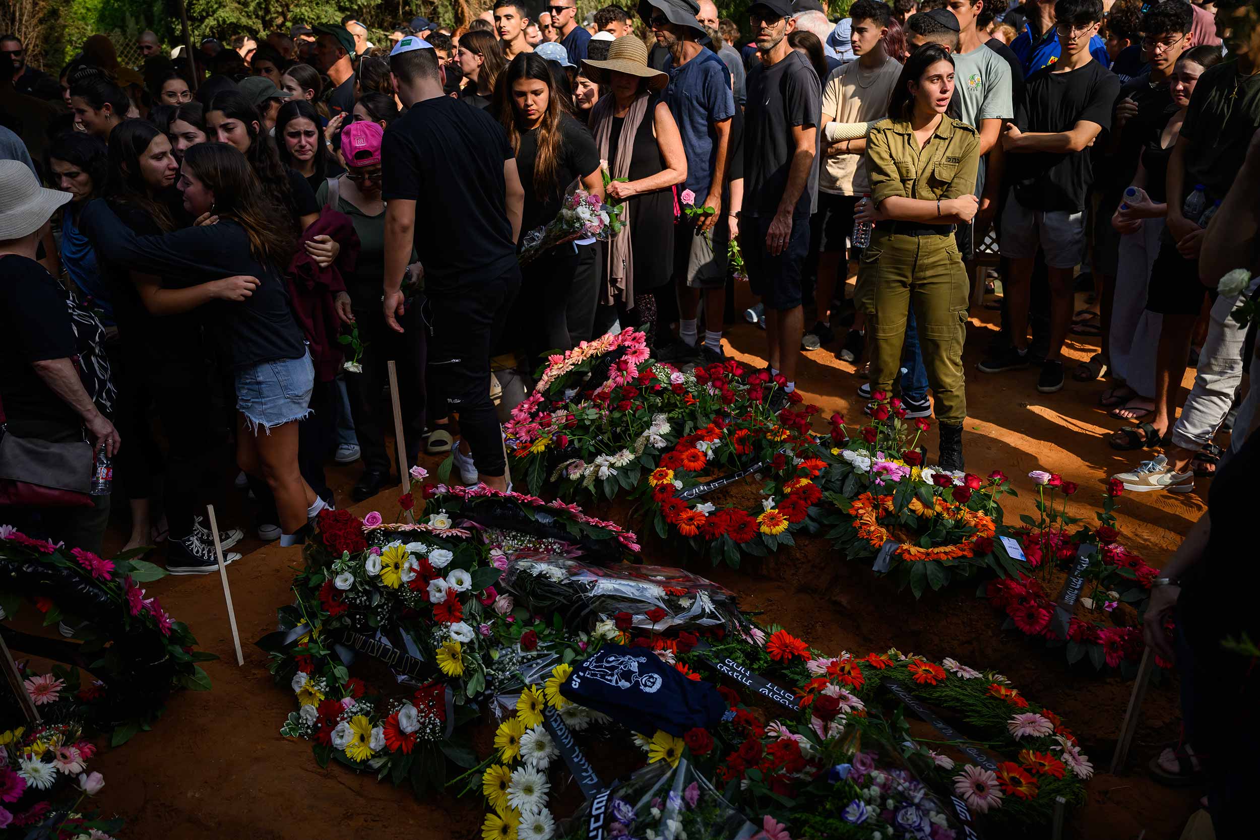 Friends and family pay their respects at the joint funerals of Dana and Carmel Becher, a mother and son who were killed during the Hamas attack of 7/10 on Kibbutz Be'eri on October 24, 2023 in Rehovot, Israel. Carmel's father was injured during the attacks in which he witnessed the deaths of his wife and son, and has since had a leg amputated. The family chose to bury Carmel with his favourite surf board. © Leon Neal/Getty Images