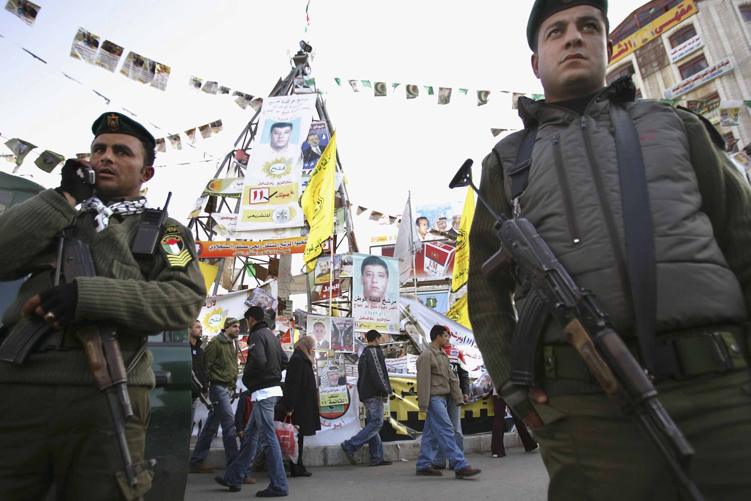 Palestinian policemen secure the Manara square, in the West Bank city of Ramallah, filed with flags and party electoral campaign posters on January 23, 2006 in a run up to the parliamentary elections. © Uriel Sinai/Getty Images
