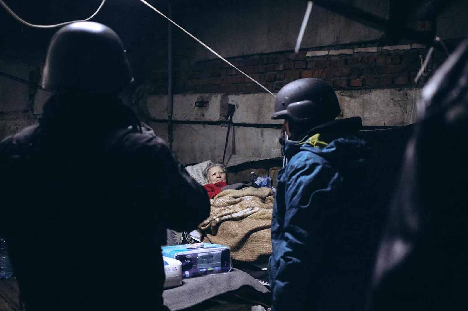 Volunteers visit a shelter. About 6,000 people remain in Bakhmut, which had a pre-war population of 73,000. The city has no electricity, no potable water, no gas and civilians rely on generators, food, water and medicine distributed by aid workers and Ukrainian forces. © Anastasia Rokytna/IWPR