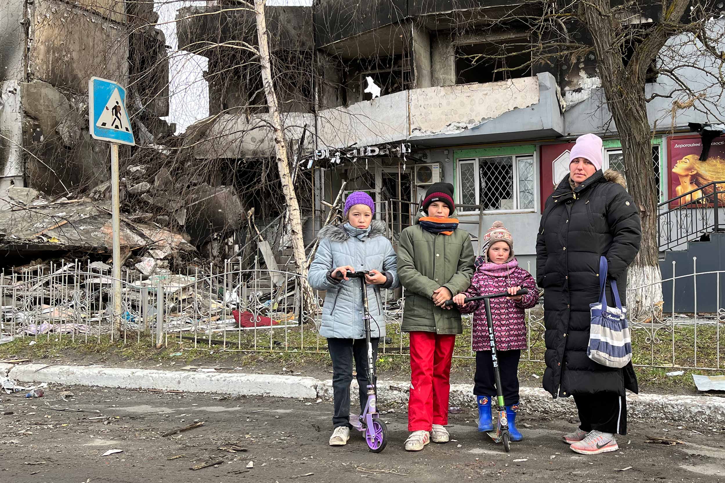 Julia and kids, amongst the ruins in Borodyanka, Ukraine, 7 Apr 2022. © IWPR