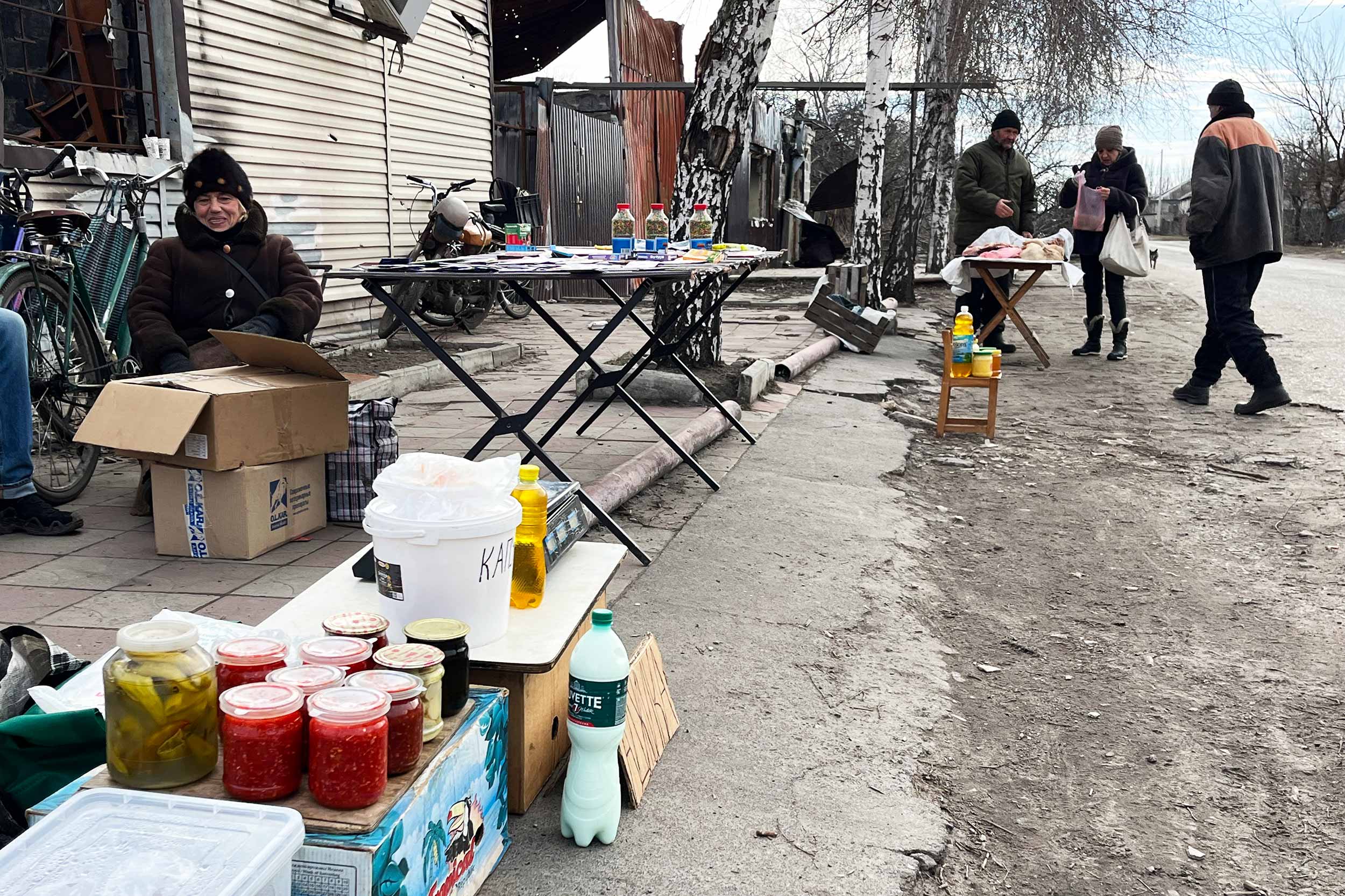 Residents sell small items on the street in Lyman, the frontline town in eastern Ukraine. Zinaida, 72, specialises in vegetable seeds, but says sales are not good because people fear there may be more shelling. © Anthony Borden