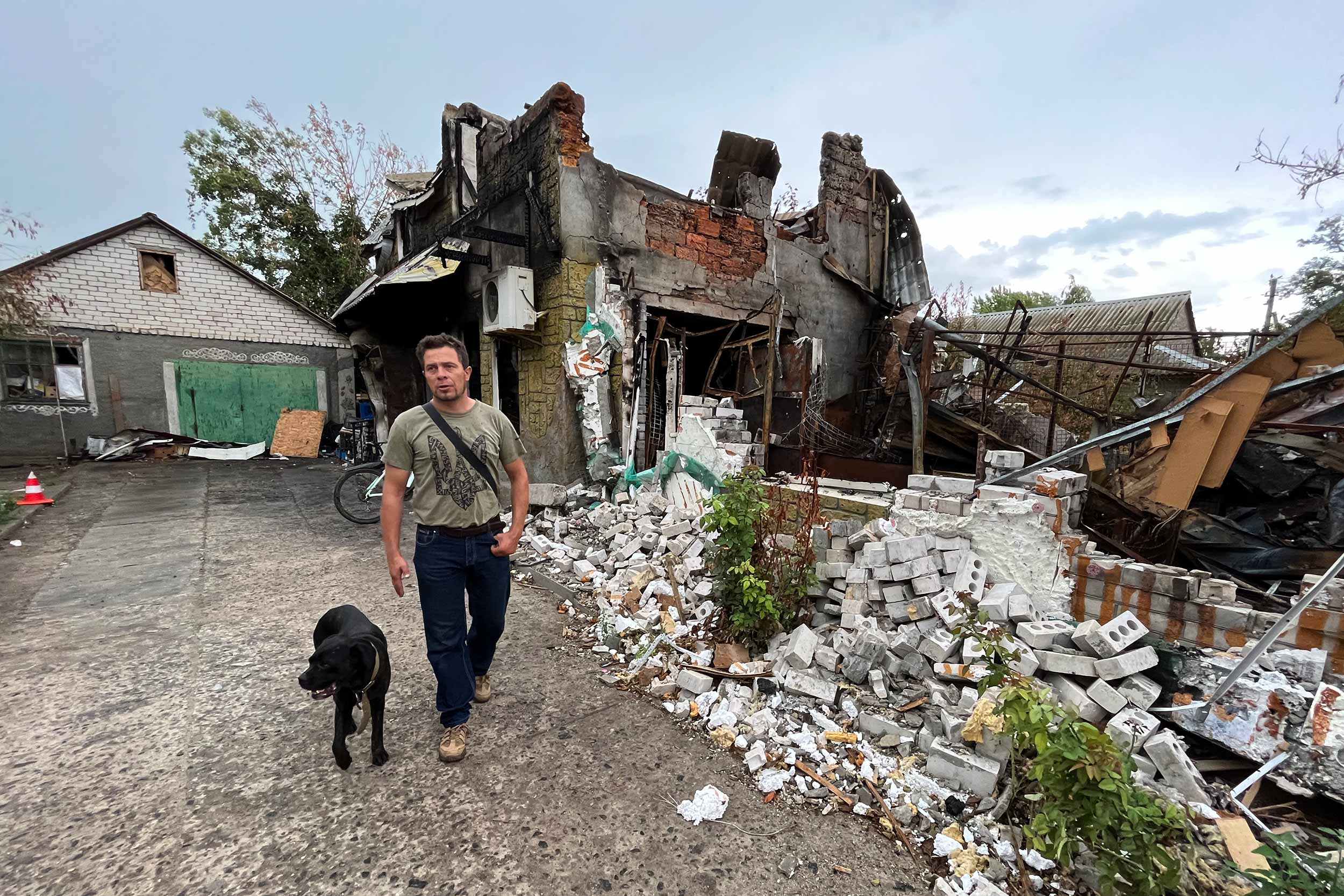 Olexander Pryhodko stands in front of his village shop, in Kotlyareve, outside of Mykolaiv, destroyed by Russian shelling in June. He plans to restore and re-open the store. © Anthony Borden
